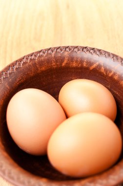 ahşap bir masa, organik ve Diyetetik gıda üzerinde seramik bir kapta tavuk yumurtası