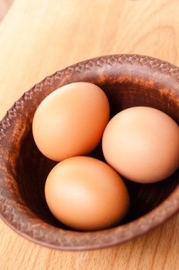 ahşap bir masa, organik ve Diyetetik gıda üzerinde seramik bir kapta tavuk yumurtası