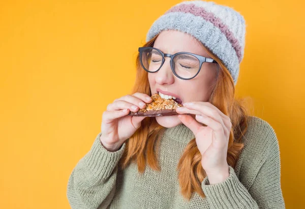 배고픈 여자가 쿠키를 음식을 맛있는 스낵을 있으며 노란색 배경에 고립되어 — 스톡 사진