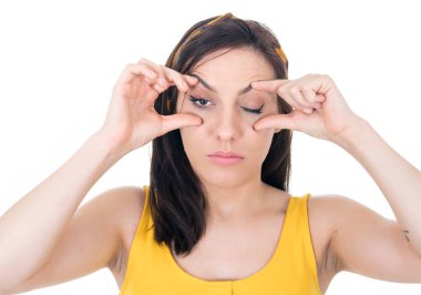 Kameraya bakan uykulu kız, beyaz arka planda izole edilmiş. Yorgun genç bir kadın. Uykulu bir ifade. Stüdyo çekimi