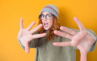 Korkak genç bir kadın, korkunç bir kaza, sarı arka planda izole edilmiş. Korkmuş kadın. Stüdyo çekimi