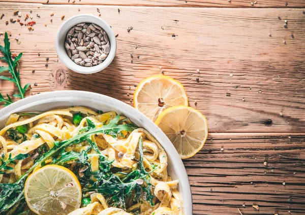 Pasta with a sour cream lemon and herbs on wooden boards. Top vie