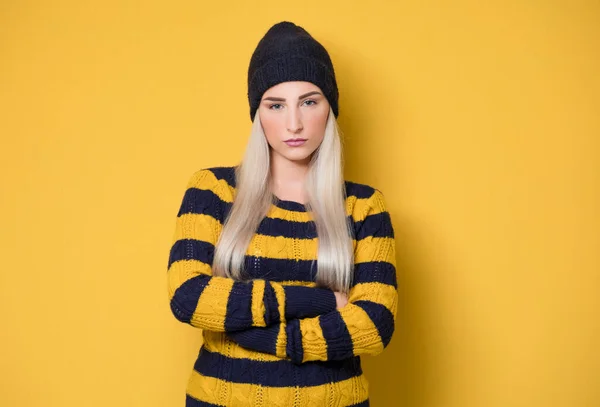 交差腕を持つ深刻な美しい女性は モデルは 黄色の背景に隔離されたウールキャップとセーターを着て かわいい女の子がカメラを見て スタジオショット — ストック写真