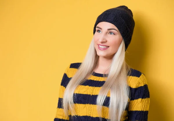 アップ見て幸せな若い女性を閉じると モデルはウールキャップとセーターを着て 黄色の背景に隔離された 笑っている女の子の肖像画 スタジオショット — ストック写真