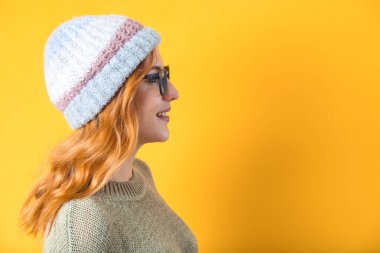 Sarı arka planda izole edilmiş, gülümseyen beyaz bir kadının yakın görüntüsü. Stüdyo çekimi