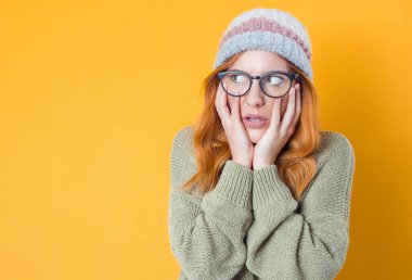 Sıkıcı kız uykulu ve isteksiz bakıyor ilgisiz, sıkıcı konsept, sarı arka planda soyutlanmış. Stüdyo çekimi