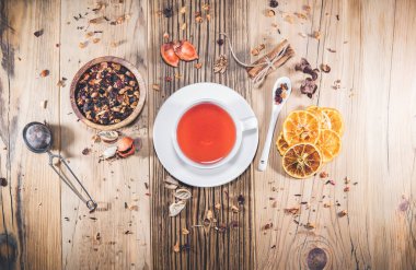 Bir fincan portakallı meyve çayı ve ahşap masada tarçın. Üst görünüm, yukarıdan