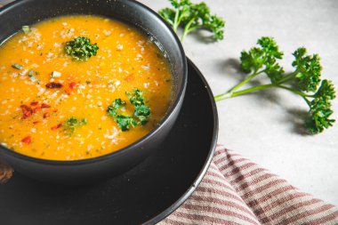 Sebze çorbasını gri mutfak masasında bir dilim ekmekle kapat. Sağlıklı yemek ya da öğle yemeğini bir kasede servis ettim.