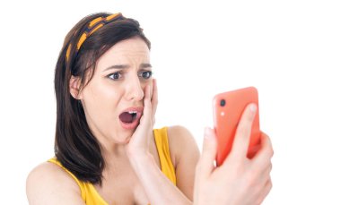 Cep telefonu olan korkmuş genç bir kadın, beyaz arka planda izole edilmiş. Elinde akıllı telefon tutan şok olmuş bir kadın. - İnanılmaz. Stüdyo çekimi