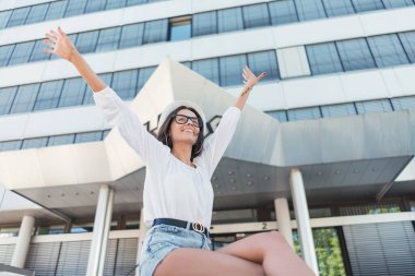 Kollarını açıp eğlenen genç bir kadın. Kollarını açmış bir kız.