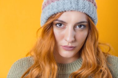 Güzel bir kadının yarım yüzü. Kadın portresi yakın çekim. Sarı arka planda izole edilmiş güzel bir kızın vesikalığı. Stüdyo çekimi