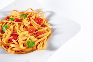 Makarnayı beyaz tabakta domates sosuyla kapat. Tagliatelle çok lezzetli.