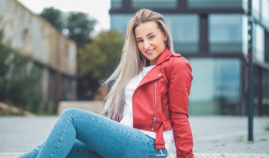 Gülümseyen genç ve güzel bir kadın kameraya bakıyor. Uzayı kopyala Açık havada gün ışığı. Olumlu duyguları olan, gülümseyen güzel bir kız. Sıradan kıyafetler giyen bir kadın. Dışarıda.