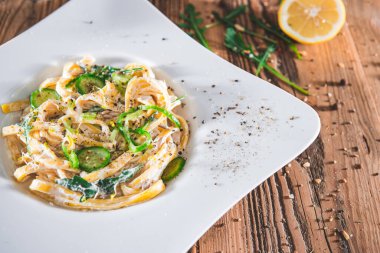 Ekşi kremalı ve otlu makarna tabağı. Tagliatelle, spagetti. Lezzetli yemek. Vejetaryen yemeği.