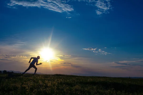 Silhouette man running on meadow — Stock Photo, Image