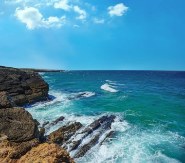 Kıyı ve deniz, güzel kayalık kıyılar. Taşlaşmış sahil ve okyanus suyu. Huzursuz mavi deniz. Atlantik Okyanusu - Portekiz