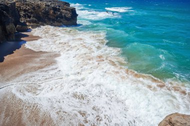 Sahil ve Deniz. Dalgalı ve okyanus köpüklü kumsal. Huzurlu deniz manzarası. Güzel bir yaz manzarası ve kumdaki kayalar. Suda sakin dalgalar. Atlantik Okyanusu Duvar Kağıdı