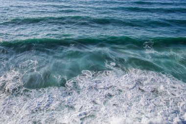 Köpüklü yüzeyi ve dalgaları olan deniz suyu. Sahildeki yeşil ve mavi akan suyun yakın çekim görüntüsü. Atlantik Okyanusu Duvar Kağıdı