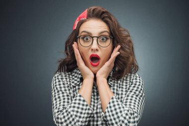 Geçmişe dönük şoka uğramış, pozitif şaşkın bakışlı, koyu gri arka plan üzerinde ifade veren bir kadın. Çılgın güzel kız. Stüdyo çekimi