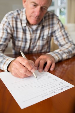 Senior Man Signing Last Will And Testament At Home clipart