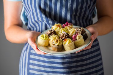 Tabak lezzetli ev yapımı kekler tutan kadın