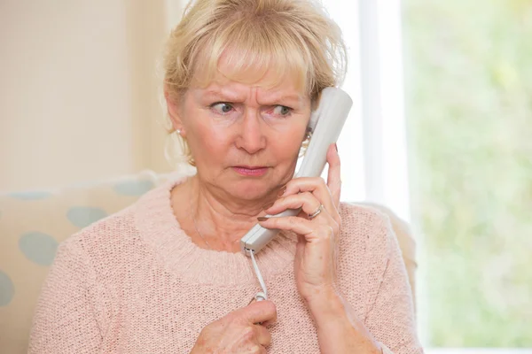 Mujer mayor preocupada contestando teléfono en casa — Foto de Stock