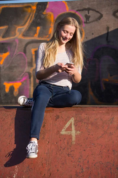 Nastoletnie dziewczyny wiadomości tekstowe na telefon komórkowy w plac zabaw dla dzieci — Zdjęcie stockowe