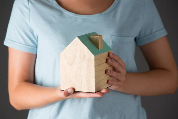 Mulher segurando modelo de casa de madeira — Fotografia de Stock