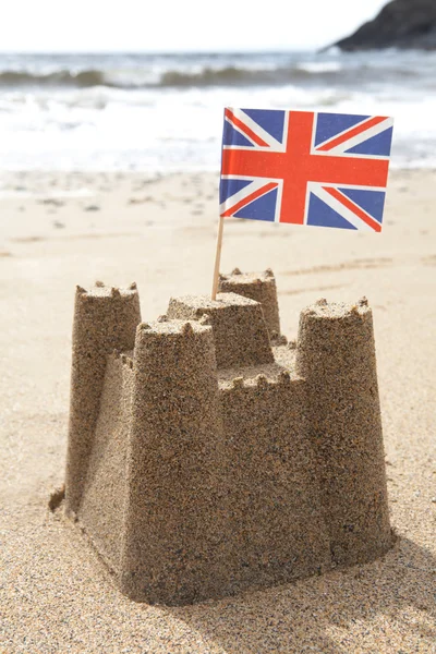 Sandcastle na praia com bandeira Union Jack — Fotografia de Stock