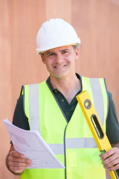 Retrato del trabajador de la construcción en el sitio del edificio con el plan de la casa — Foto de Stock