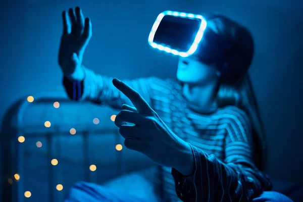 在卧室里玩电子游戏的少女晚上头戴虚拟现实耳机 — 图库照片