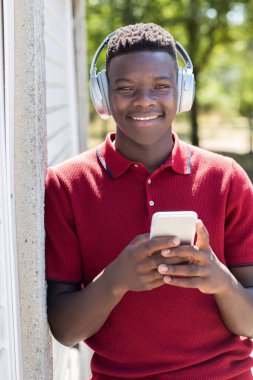 Dışarıdaki Genç Çocuğun Portresi Cep telefonundan Kablosuz Kulaklığa Müzik