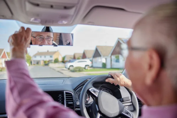 Lächelnder Senior Genießt Autofahren Und Stellt Rückspiegel Ein — Stockfoto