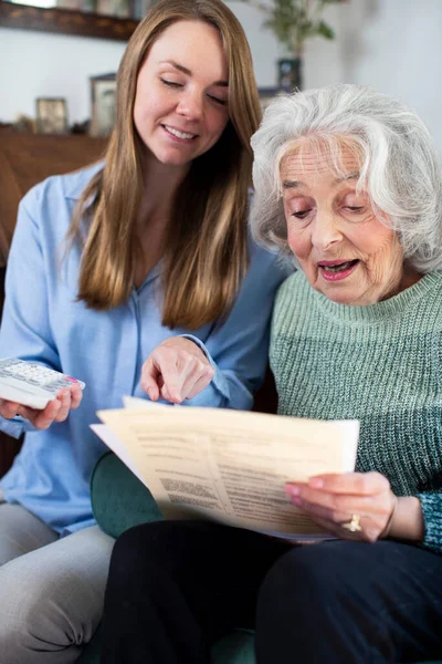 Kobieta Pomaga Starszemu Sąsiadowi Rachunkami Papierami — Zdjęcie stockowe