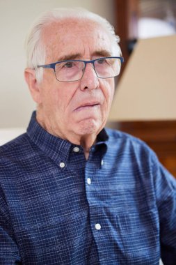 Portrait Of Senior Man At Home Suffering From Stroke Showing Dropped Side Of Face clipart