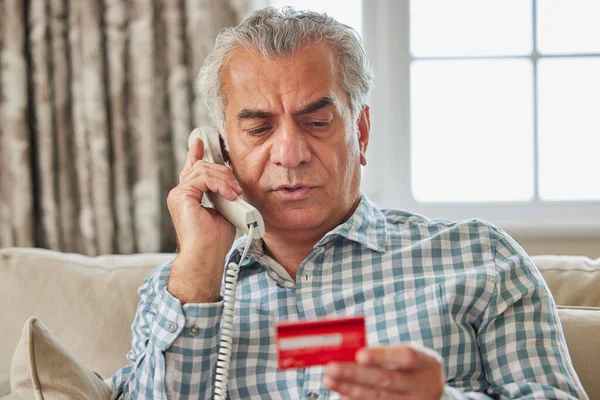 Dojrzały Mężczyzna Domu Podając Dane Karty Kredytowej Telefonie — Zdjęcie stockowe