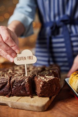 Pastanede Satış Asistanı Glüten Bedava Etiketi Taze Fırınlanmış Çikolatalı Brownie 'lere Koyuyor