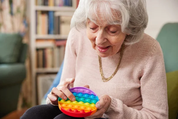 Senior Woman Using Colourful Fidget Toy Improve Mental Stimulation Home — Stock Photo, Image