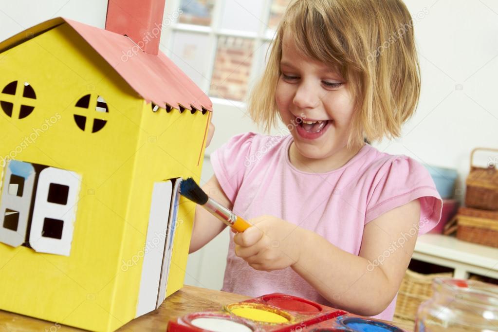 Young Girl Painting Model House Indoors