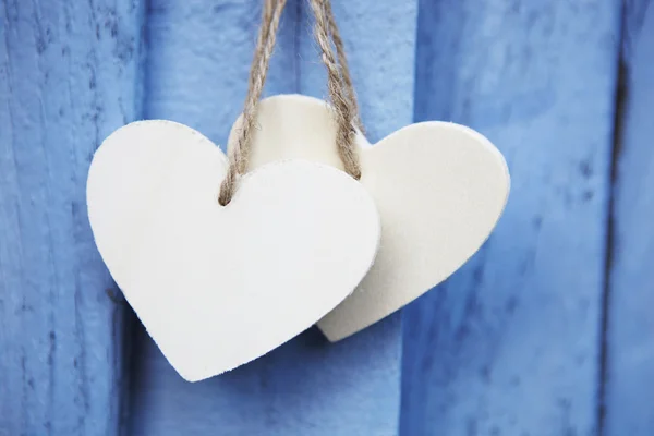 Two Wooden Hearts Hanging On Blue Wooden Surface — Stock Photo, Image