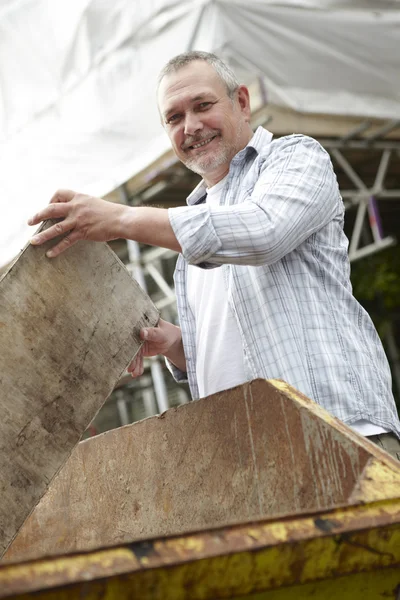 Builder Putting Waste Into Rubbish Skip Outside House — Stock Photo, Image