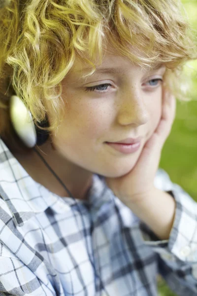 Niño joven con auriculares al aire libre — Foto de Stock