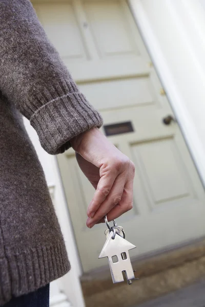 Kvinna som står utanför nya hem anläggning nyckel — Stockfoto