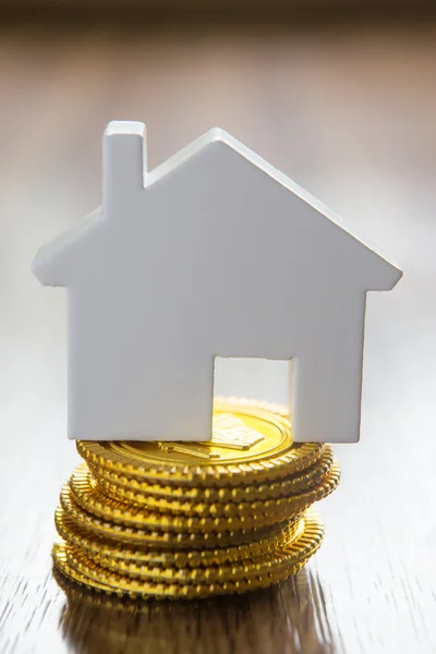 Model huis op stapel van gouden munten — Stockfoto