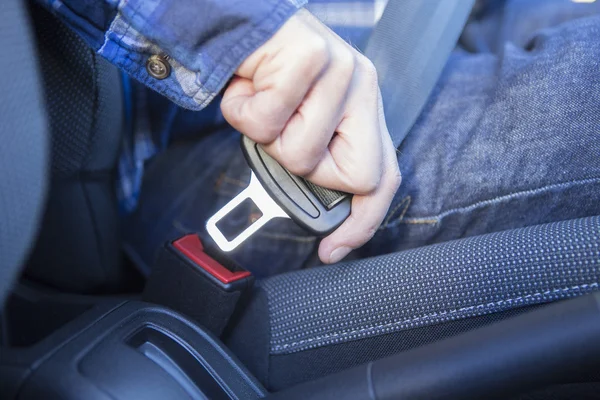 Primer plano de la persona en el cinturón de seguridad de sujeción de automóviles — Foto de Stock