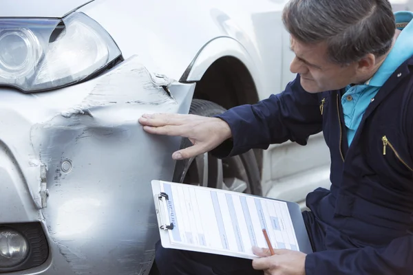 Auto taller mecánico inspeccionar daños a coches y relleno en R —  Fotos de Stock