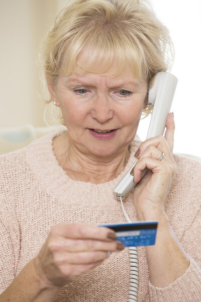 Senior Woman Giving Credit Card Details On The Phone