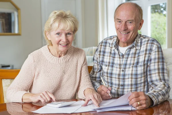 Heureux couple de personnes âgées examinant les finances domestiques ensemble — Photo