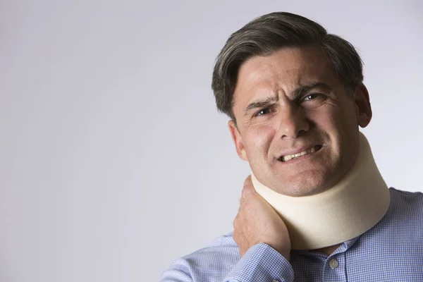 Studio Shot Of Man In Pain Wearing Neck Brace — Stock Photo, Image