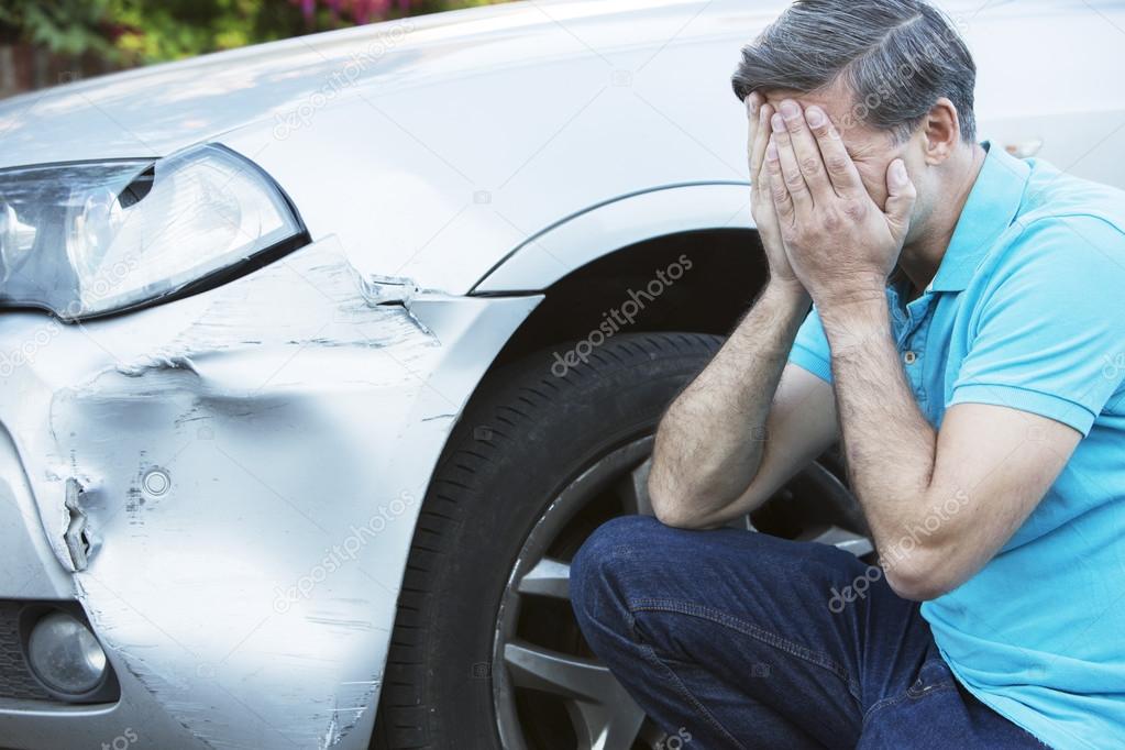 Unhappy Driver Inspecting Damage After Car Accident